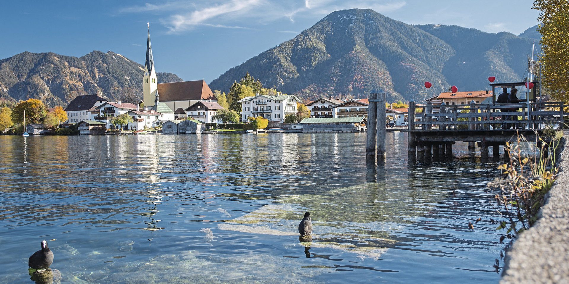 Blick auf den Tegernsee mit Kirche und Bergen